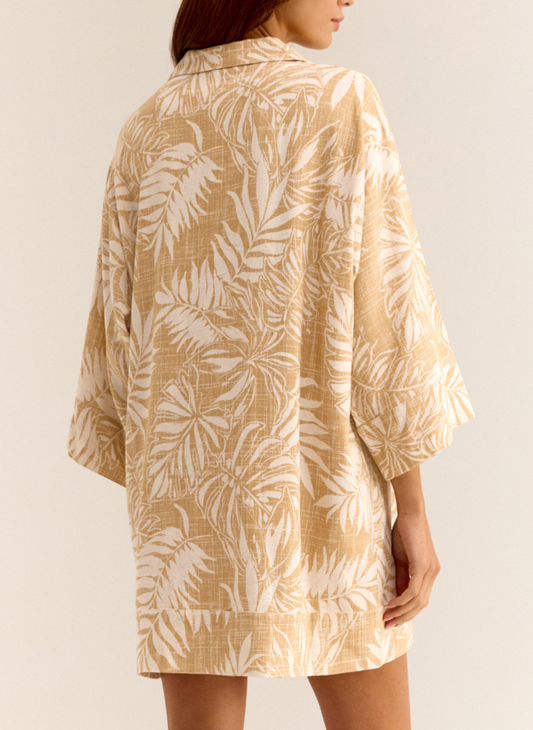 Back view of model wearing golden Palm Dress with front buttons, 3/4 sleeves, and collared neckline.