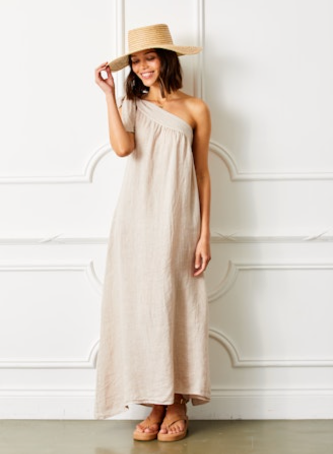 full view of model wearing the Suzy D Siena Linen On Shoulder Dress. Model is standing in front of a white back ground.