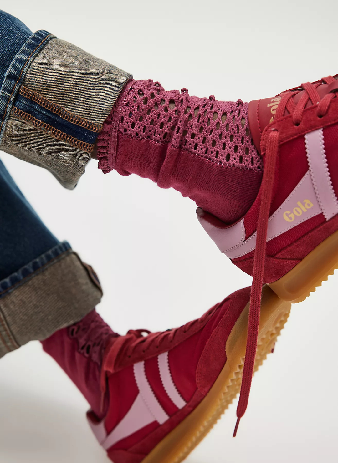 Up close view of model wearing the Free People Rubies Crochet Socks. Model is wearing red shows and denim pants.
