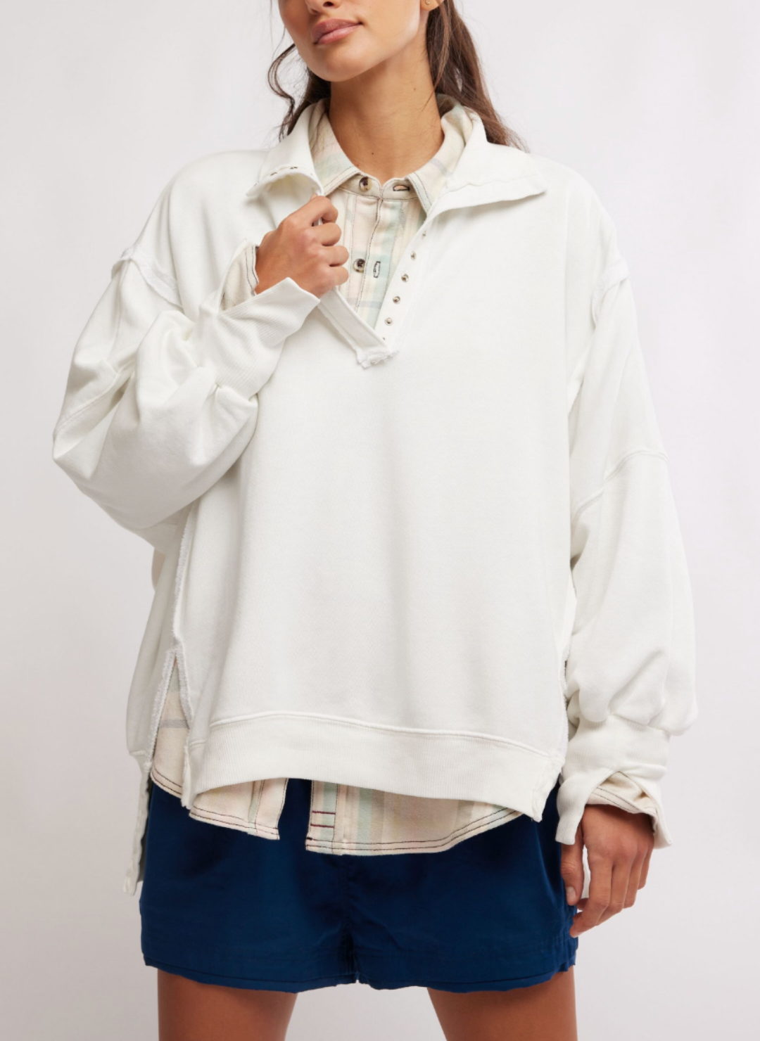 Model is wearing White colored Camden Pullover Sweatshirt with a pastel button up shirt underneath.