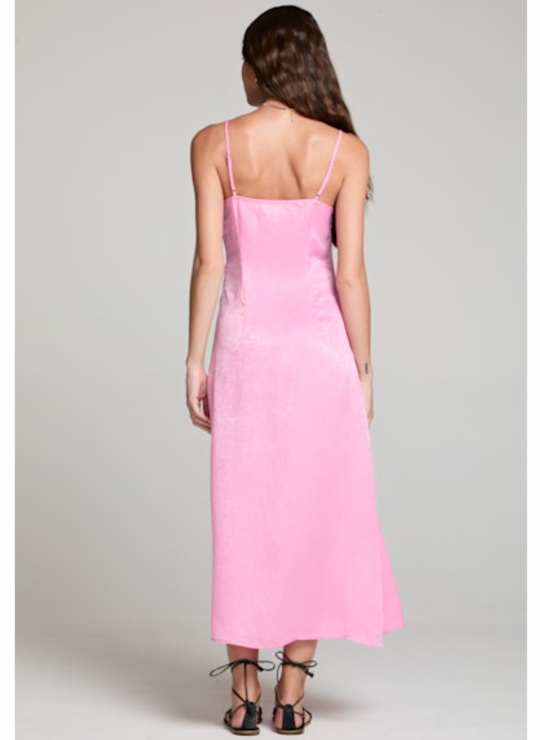 Back view of model wearing the Saltwater Luxe Midi Tank Dress paired with black sandals. Model is standing in front of grey background.