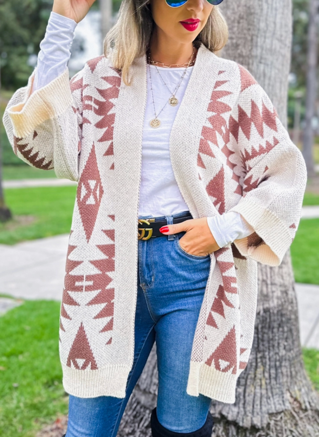 Model is wearing southwest printed open cardigan. Models one hand is in pocket to display the sleeve and overall fit.