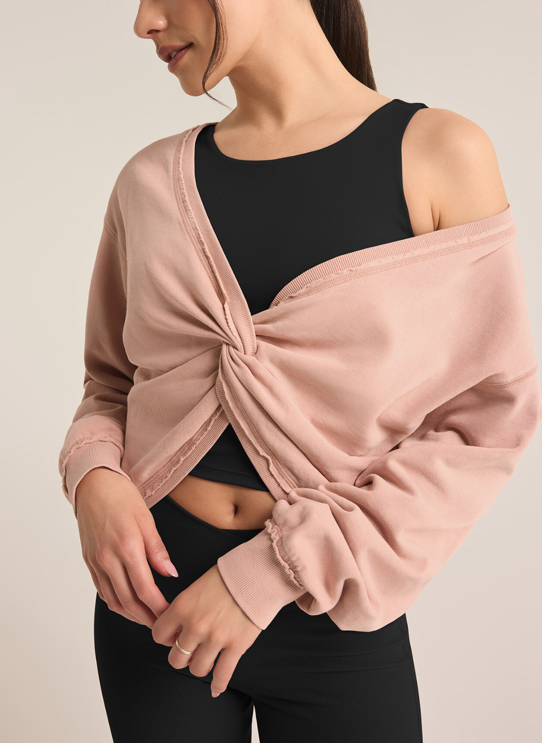Model reversed the sweater and is wearing the twist on the front layered over a black tank.
