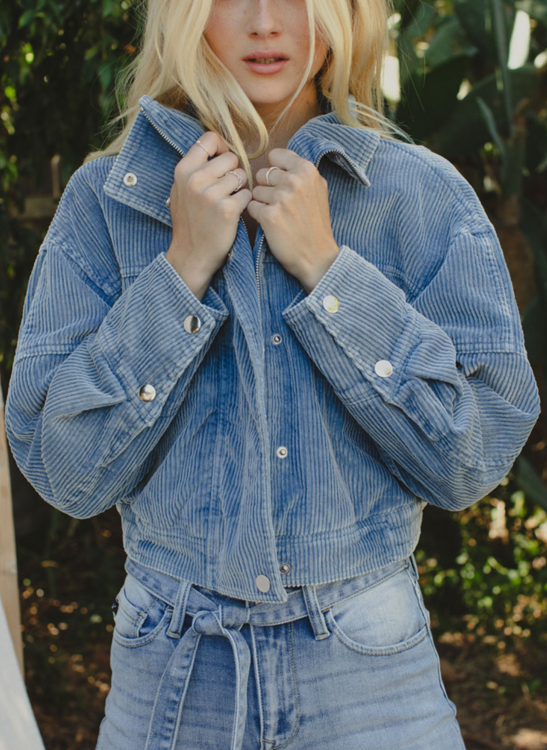 Up close view of model wearing Trailblazer Cord Crop Jacket. Model is also outside and wearing denim pants.