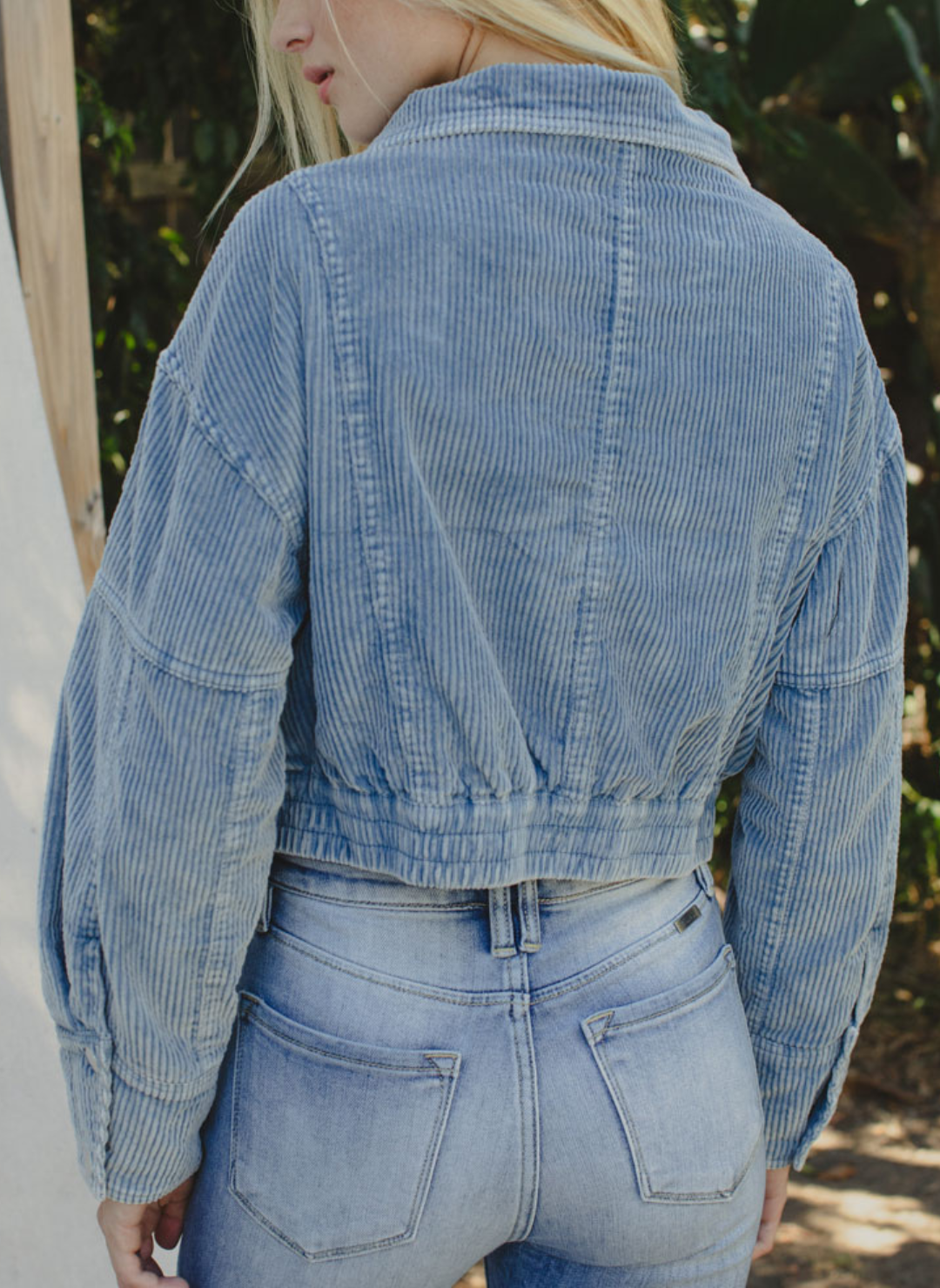 Full back view of model wearing Trailblazer Cord Crop Jacket. Model is also outside and wearing denim pants.