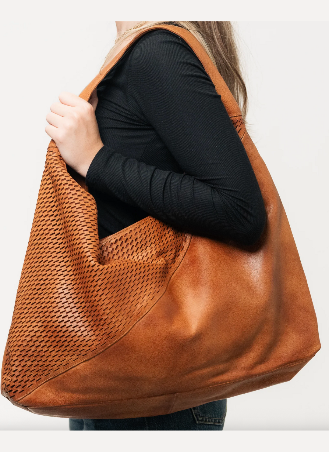 Woman carrying tan Latico Lindsey Laser Cut Tote shoulder bag with wide strap