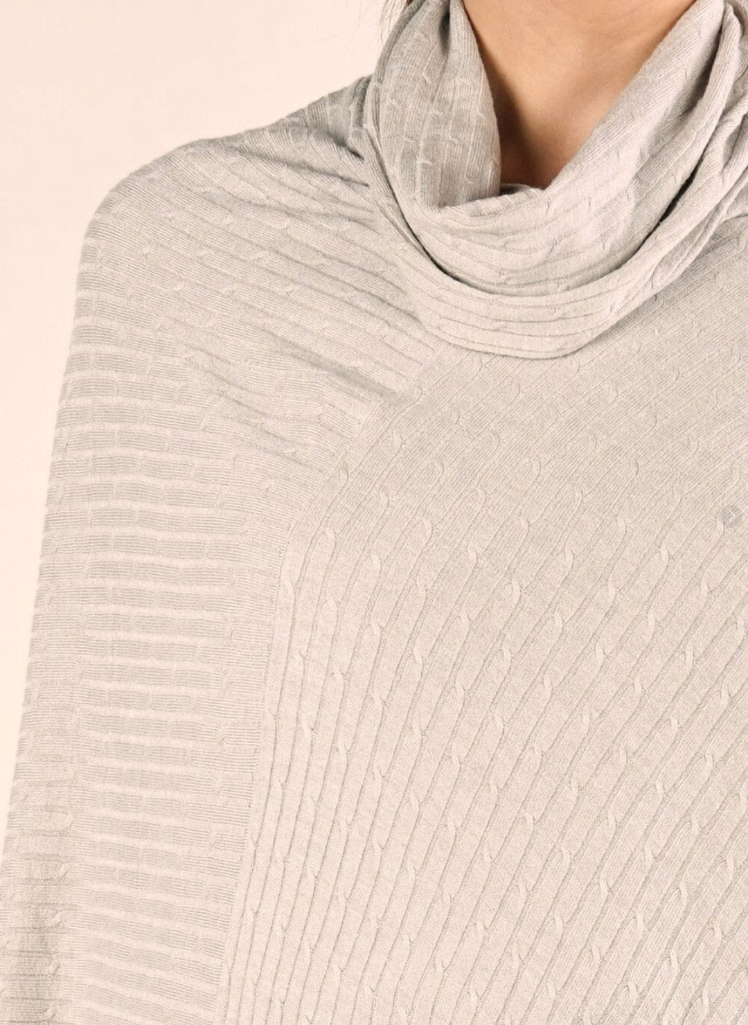 Close-up of a ribbed knit sweater with a high collar on a beige background