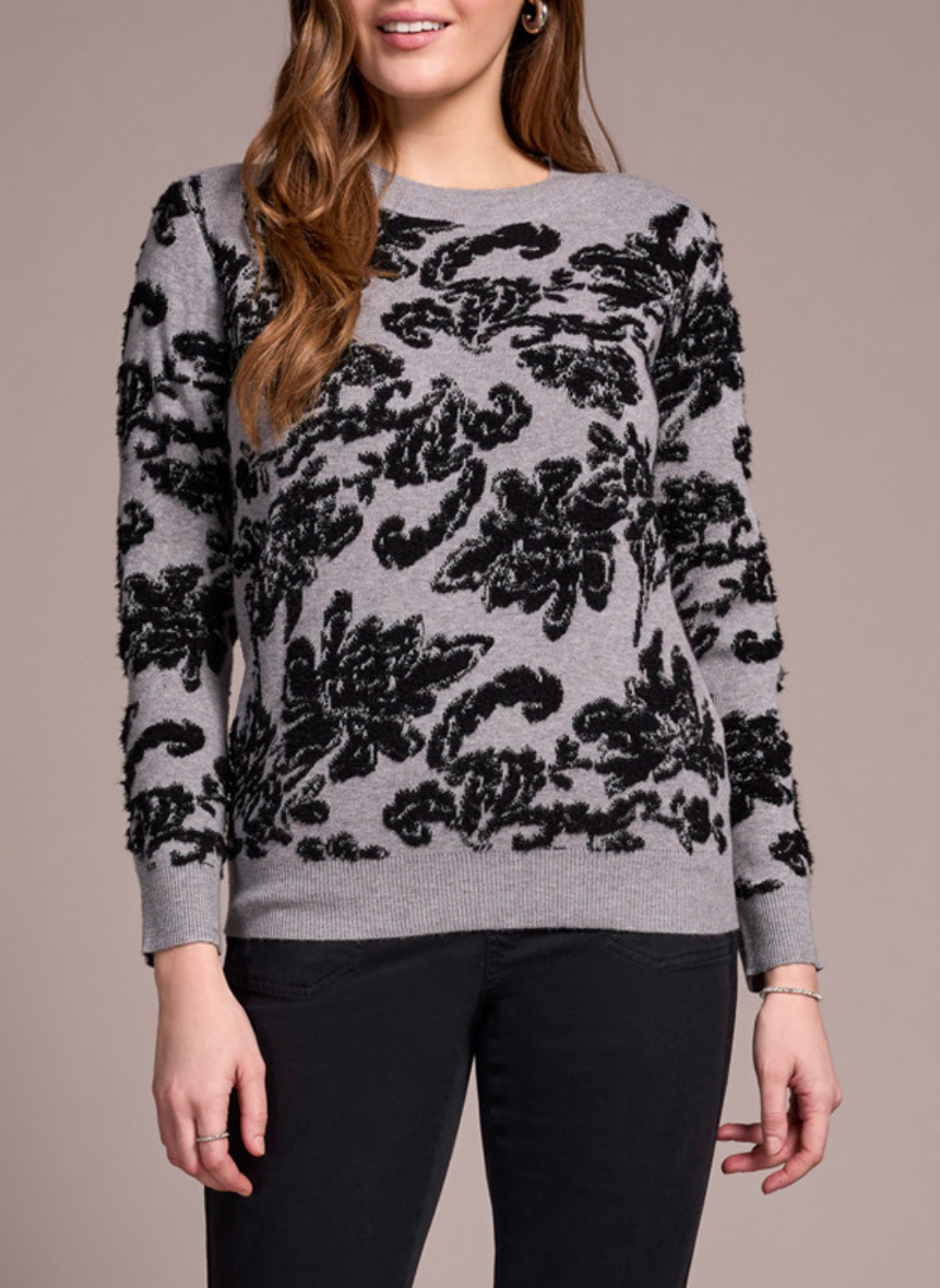 Model wearing Tribal Night Flower Crew Neck Sweater in grey with black floral jacquard pattern.