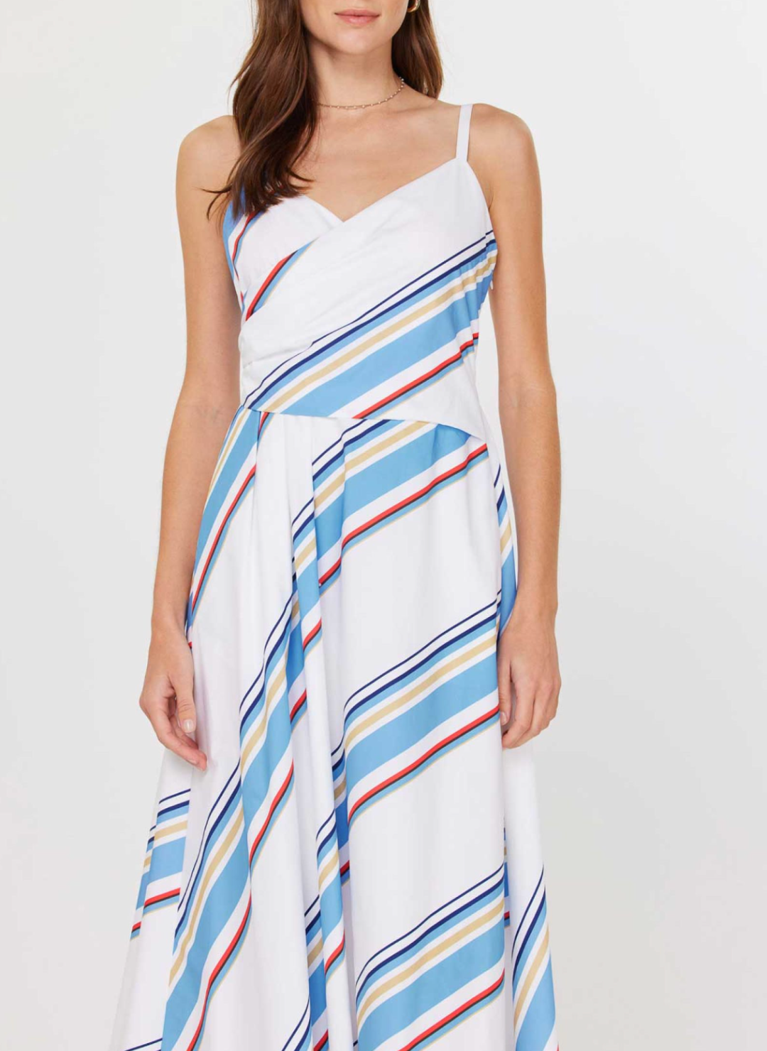Front and back views of the Current Air Juliette V-Neck Wrap Midi Dress: a white cotton poplin midi dress with adjustable spaghetti straps, V-neck wrap bodice, sky blue/navy/red/beige diagonal stripes, smocked back panel, side seam zipper, and self-fabric waist tie, modeled with silver slide sandals.