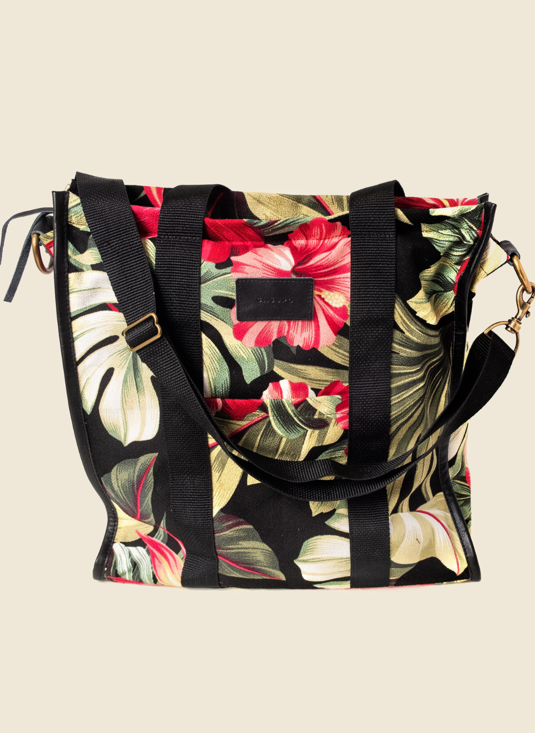 Casupo upcycled canvas and leather tote bag in tropical hibiscus print with interior zip pocket, black straps, and gold-tone hardware; handcrafted in Los Angeles.