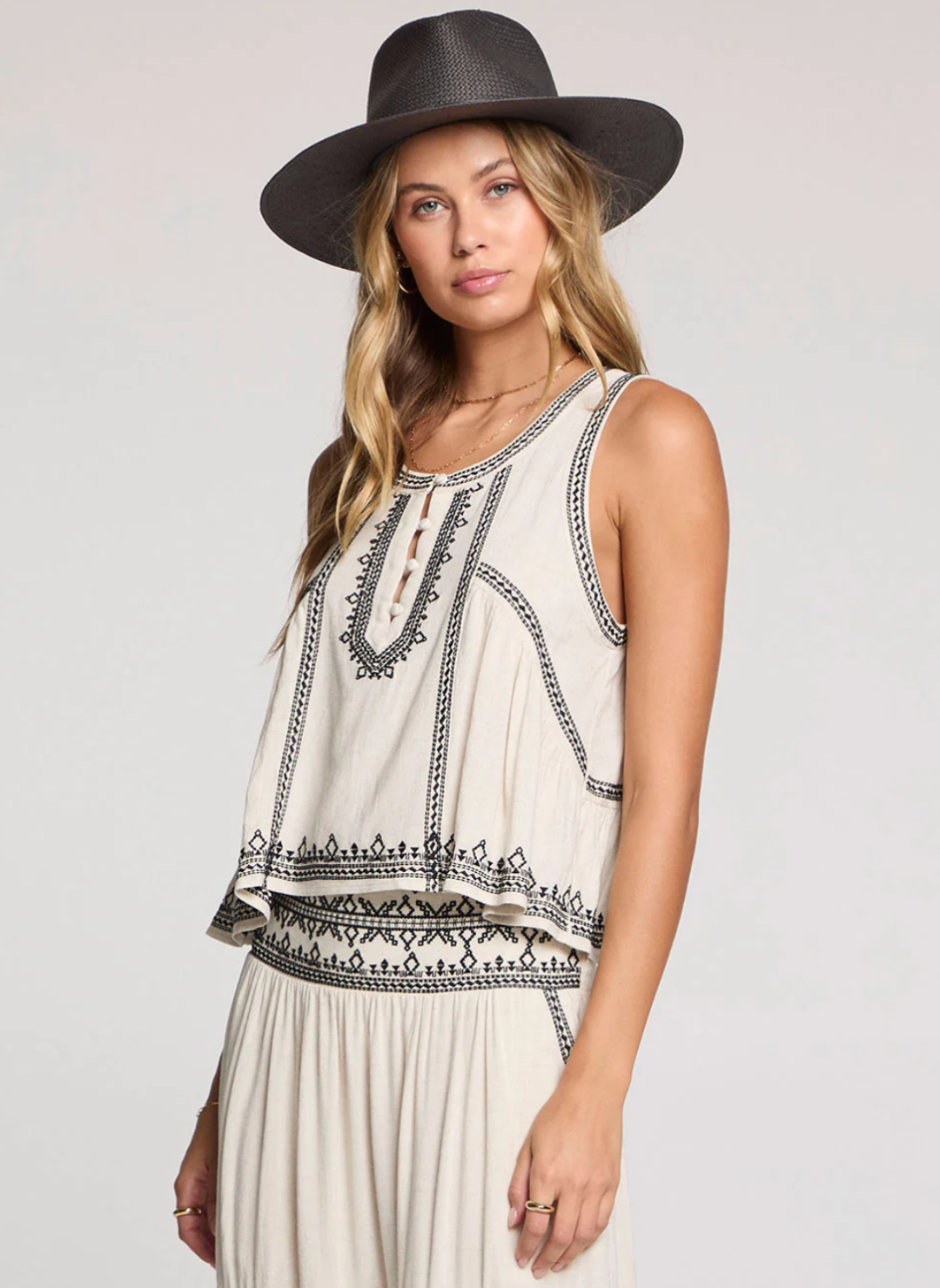 Model wearing the Saltwater Luxe Quinley Embroidered Tank in cream with black embroidery, styled with the matching embroidered skirt and a wide-brim hat for a boho-chic summer look.