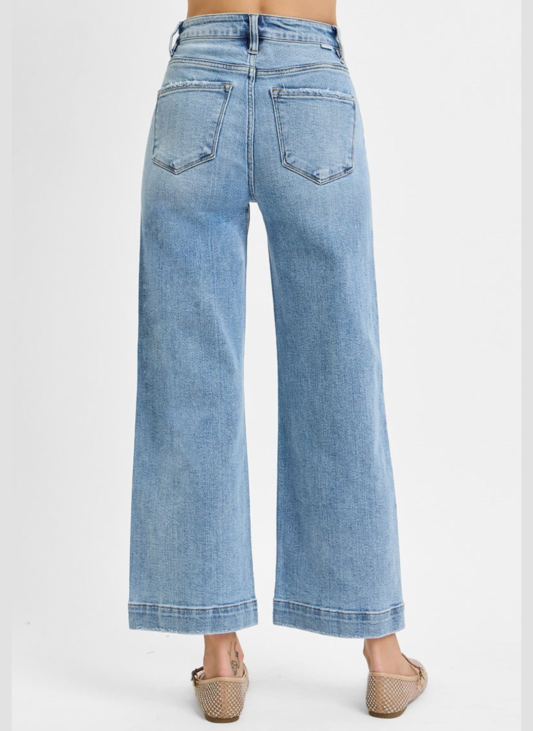 Light blue jeans worn by a person on a white background