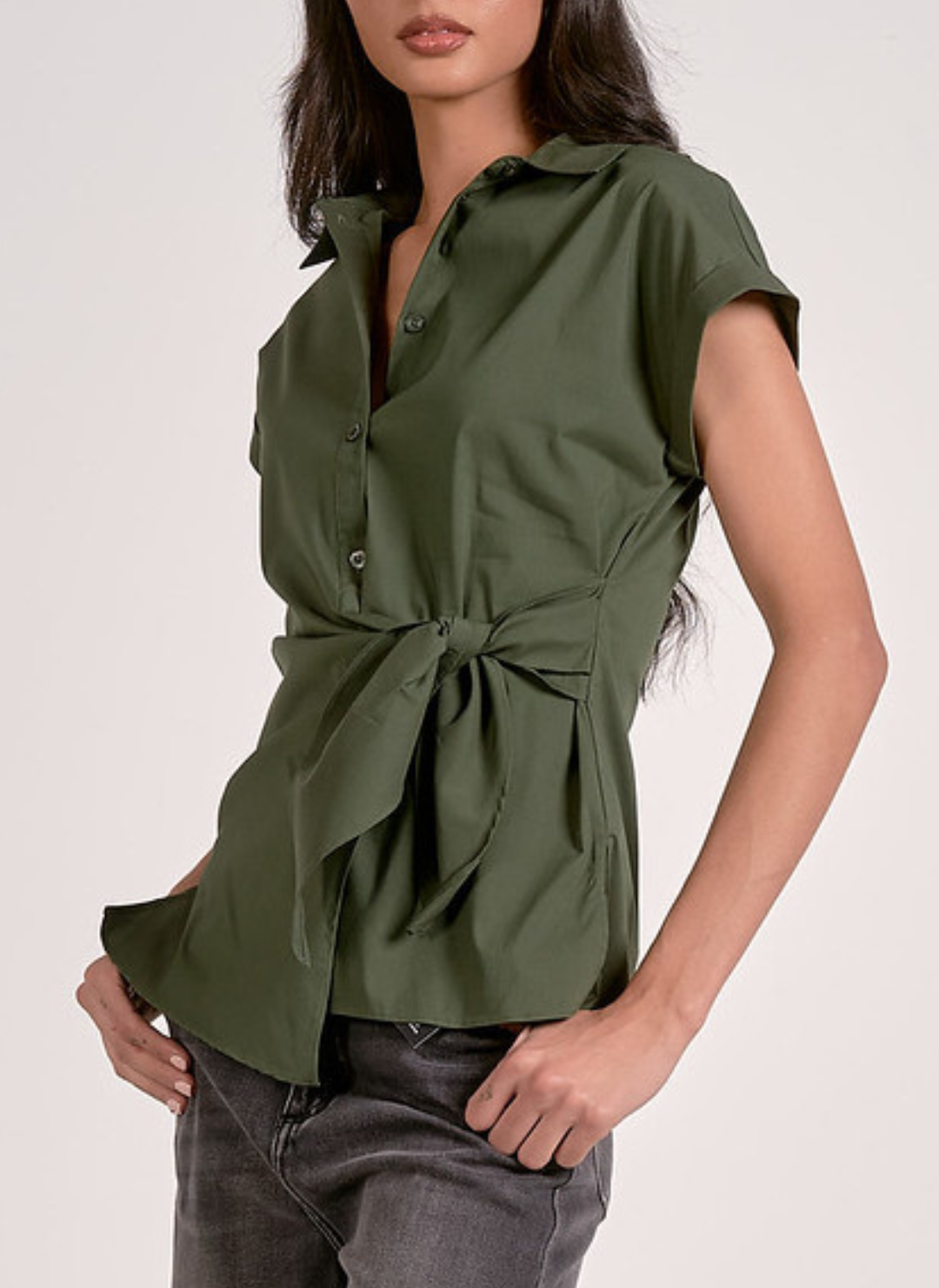 Olive green short-sleeve button-up blouse with a collared neckline, front tie waist detail, and tailored fit, styled with dark wash jeans for a chic casual look.