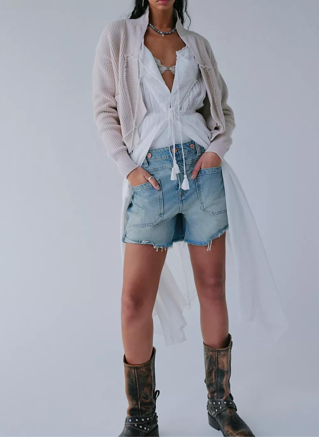 Full size view of model wearing Palmer Short FP with brown boots. Model is also wearing a white top and cream cardigan along with a blue and black necklace.