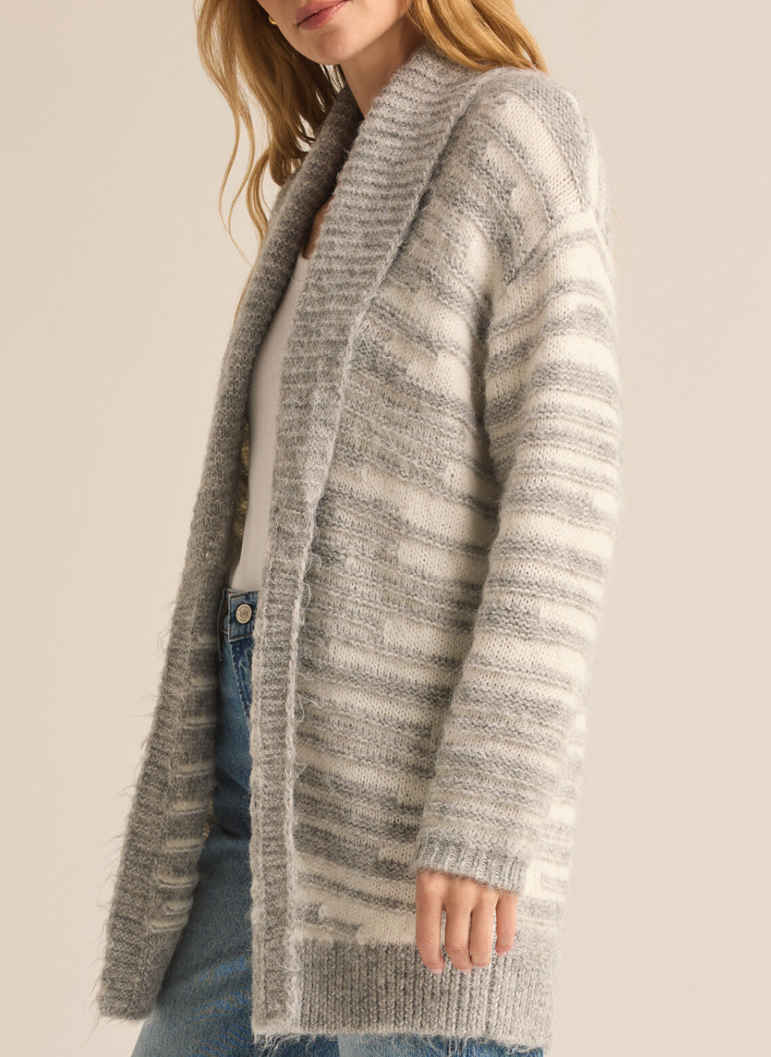 Model is wearing Level Up Cardigan turned to the side showing striped detail on sleeve of cardigan.