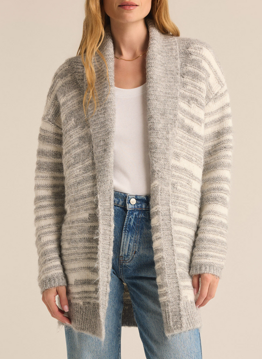 Model is wearing Level Up Cardigan with a white top underneath paired with denim jeans. Front view.