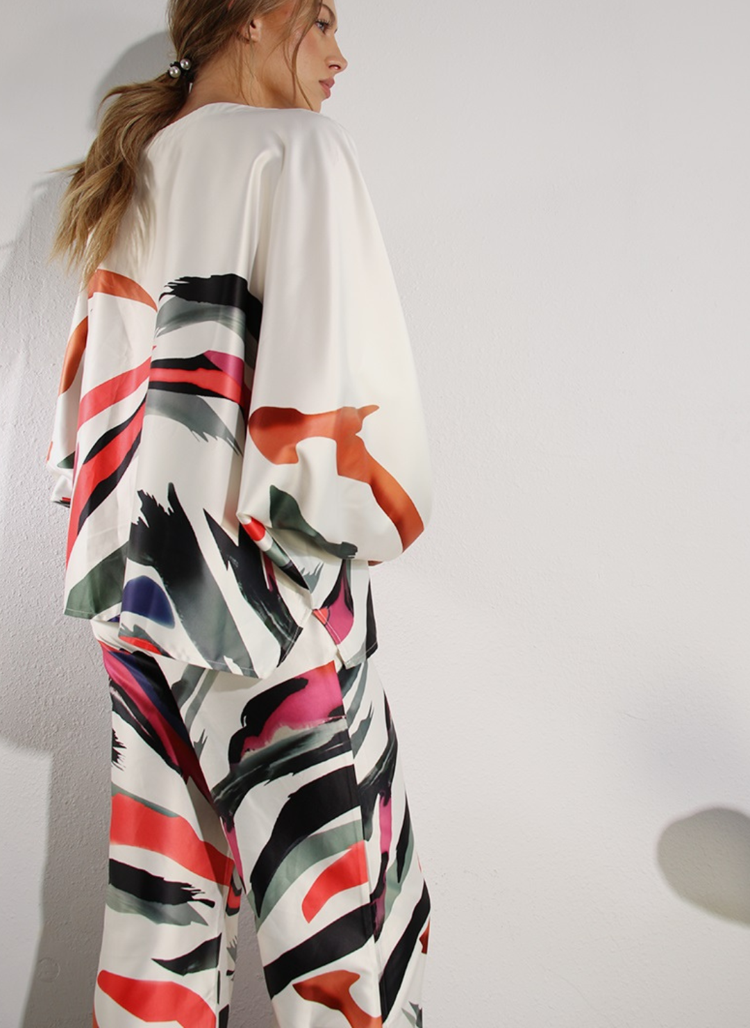 Back view of model wearing Paint Me Pretty Pant with matching top. Model has hands crossed in front of her.