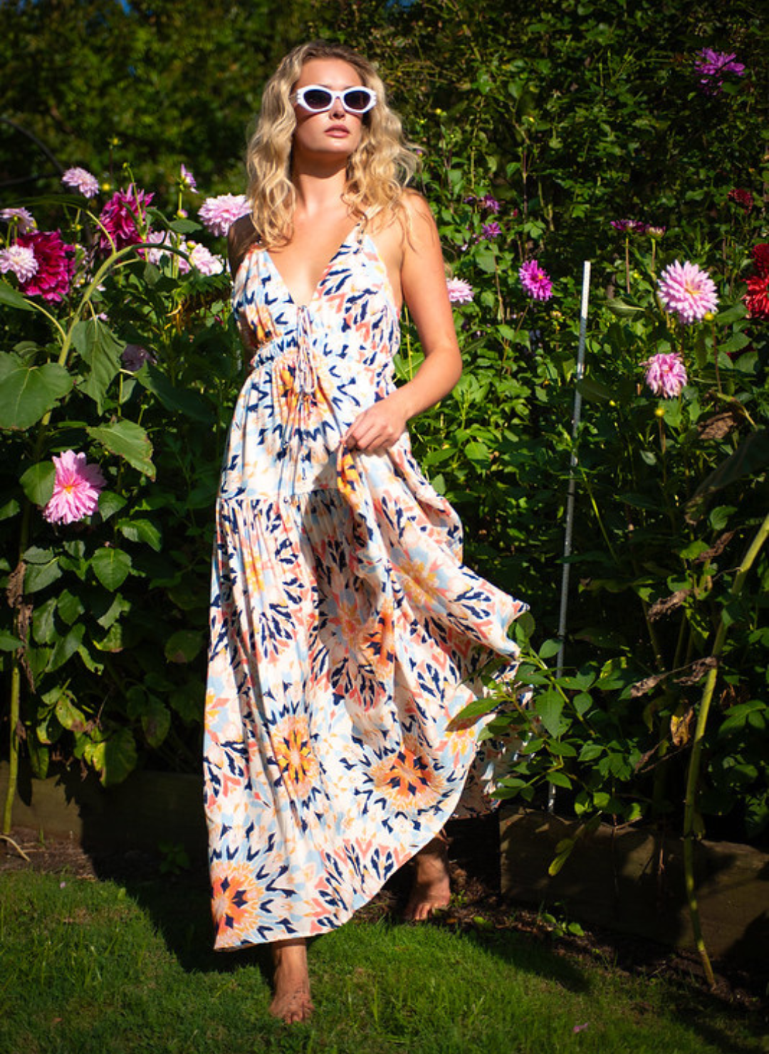 Boho multi-color maxi dress with tie front and smocked waist, adjustable straps, and bold sunset-inspired print – available at August Boutique Ripon.