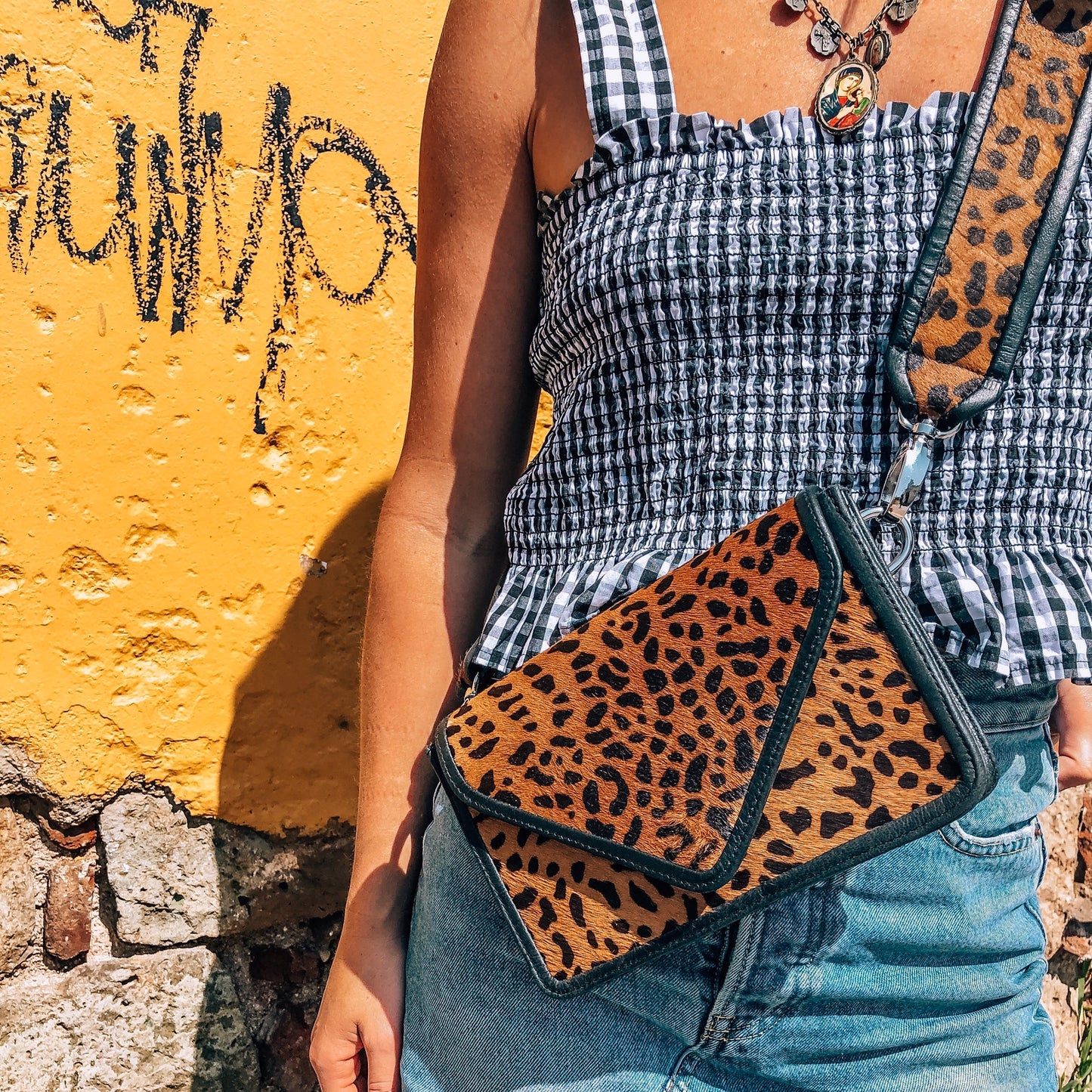 Front view of model wearing the cheetah purse with strap attached.