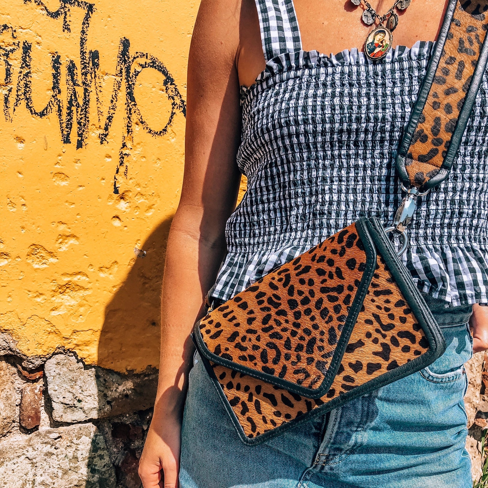 Front view of model wearing the cheetah purse with strap attached.