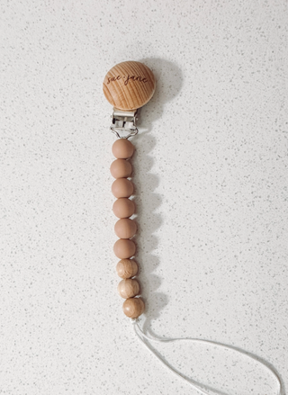 Wooden pacifier clip with beads on a white background