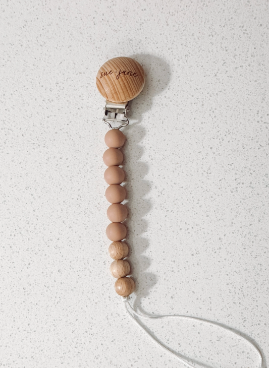 Wooden pacifier clip with beads on a white background
