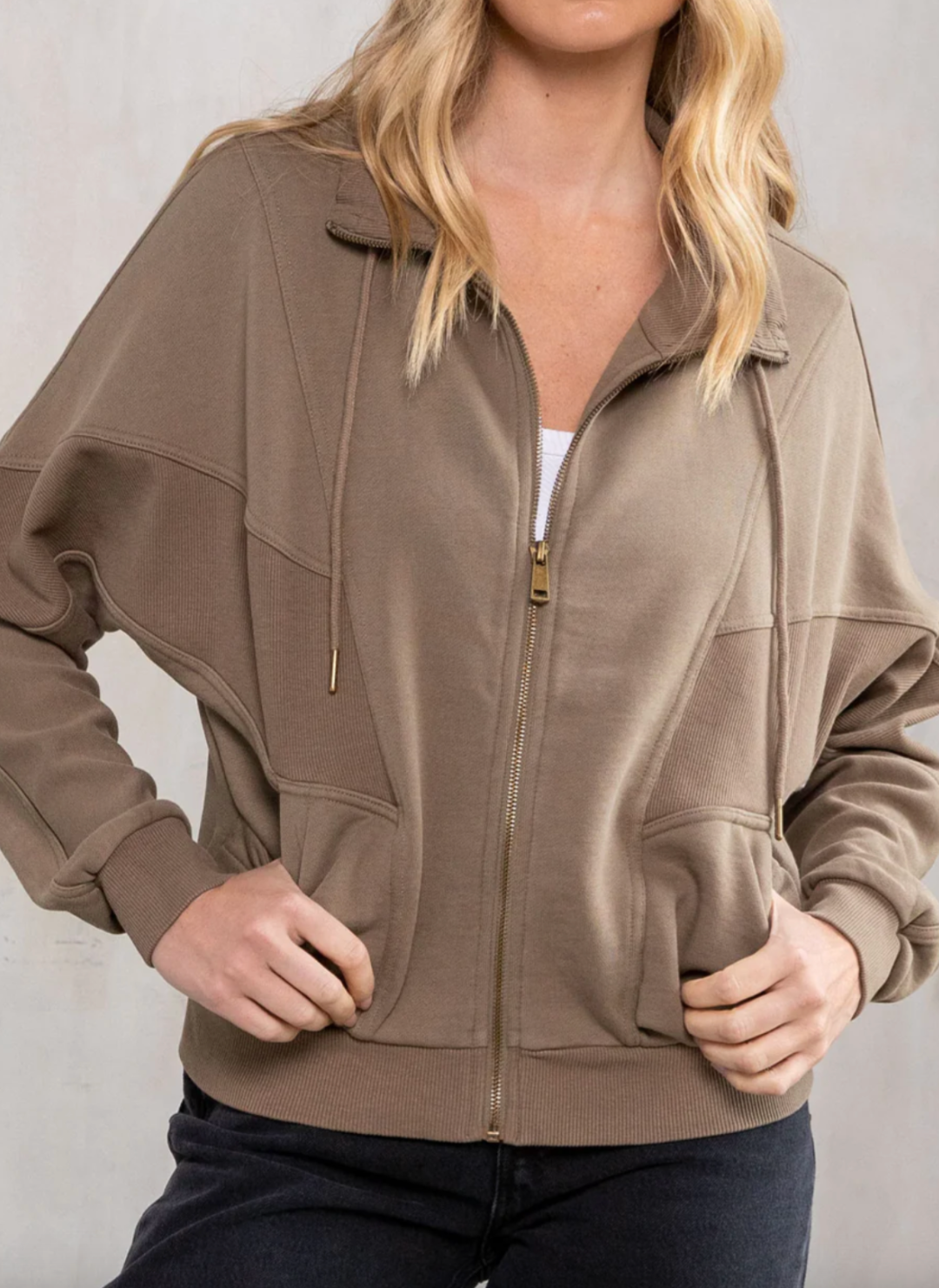 Front view of the model wearing the LS Vivian Vintage Wash Zip up Sweatshirt showing it has a zip closure. The model is showing that it has front pockets. Showing the texture and different pattern of the sweatshirt.