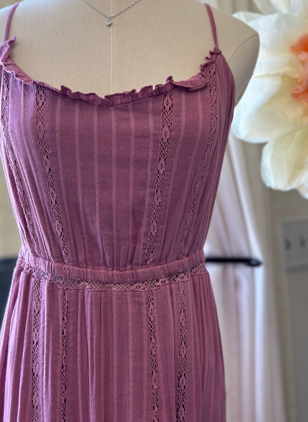 Up close view of ZS Rose Maxi Dress. Model is standing in front of window.