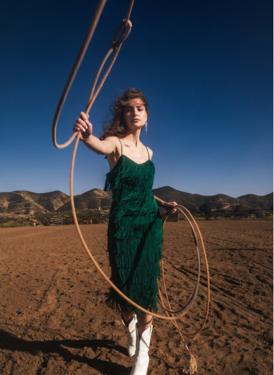 Model throwing lasso wearing Gi Fringe Strap Dress with vibrant green color and fun fringe.