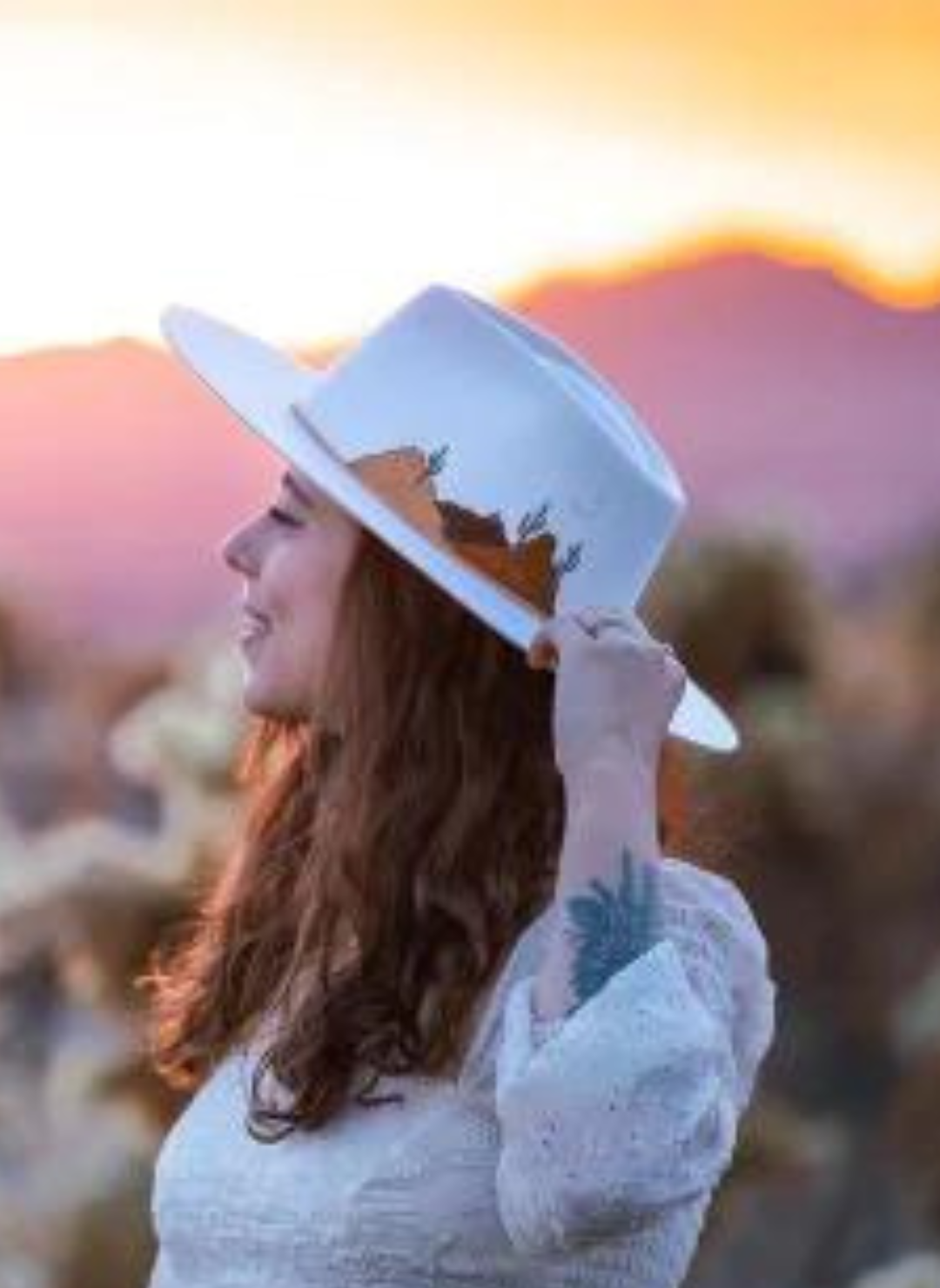 Side view of model wearing cream colored Grand Canyon Hat with hand-embroidered desert scene.