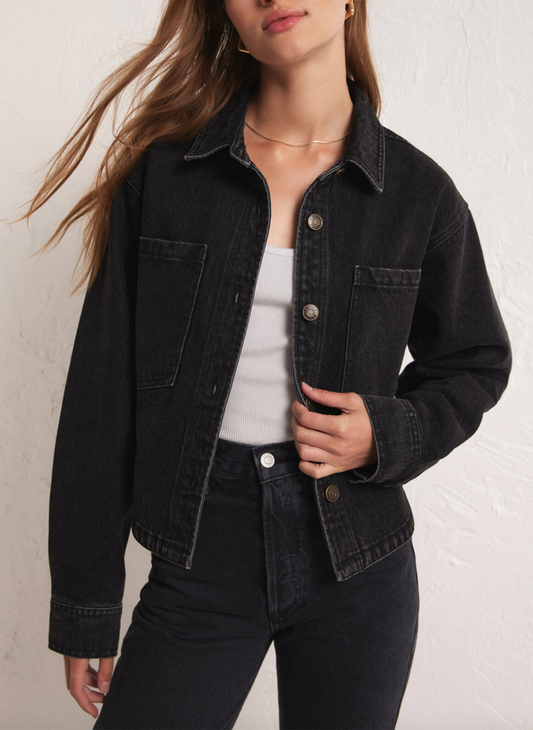 Full view of model wearing the ZS Dropped Denim Jacket with black denim pants and a white top. White background. 