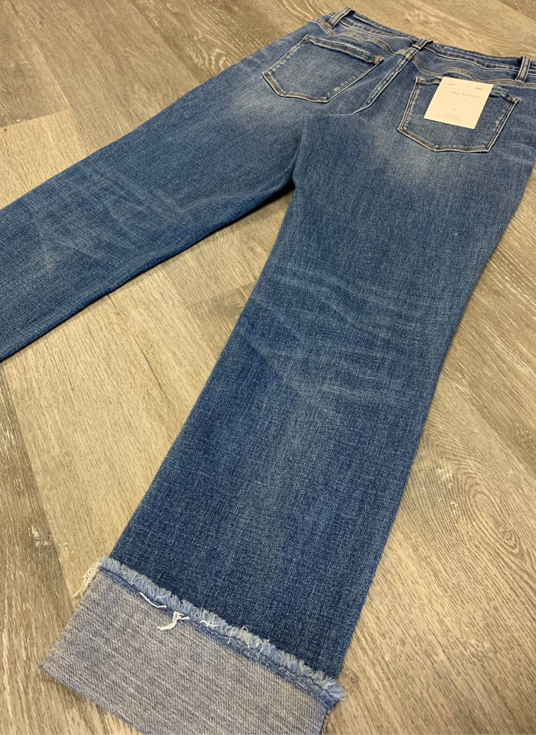 Back View of the Helen High Rise Regular Straight Jeans with cuffs at the bottom showing off the texture and pockets on the back.