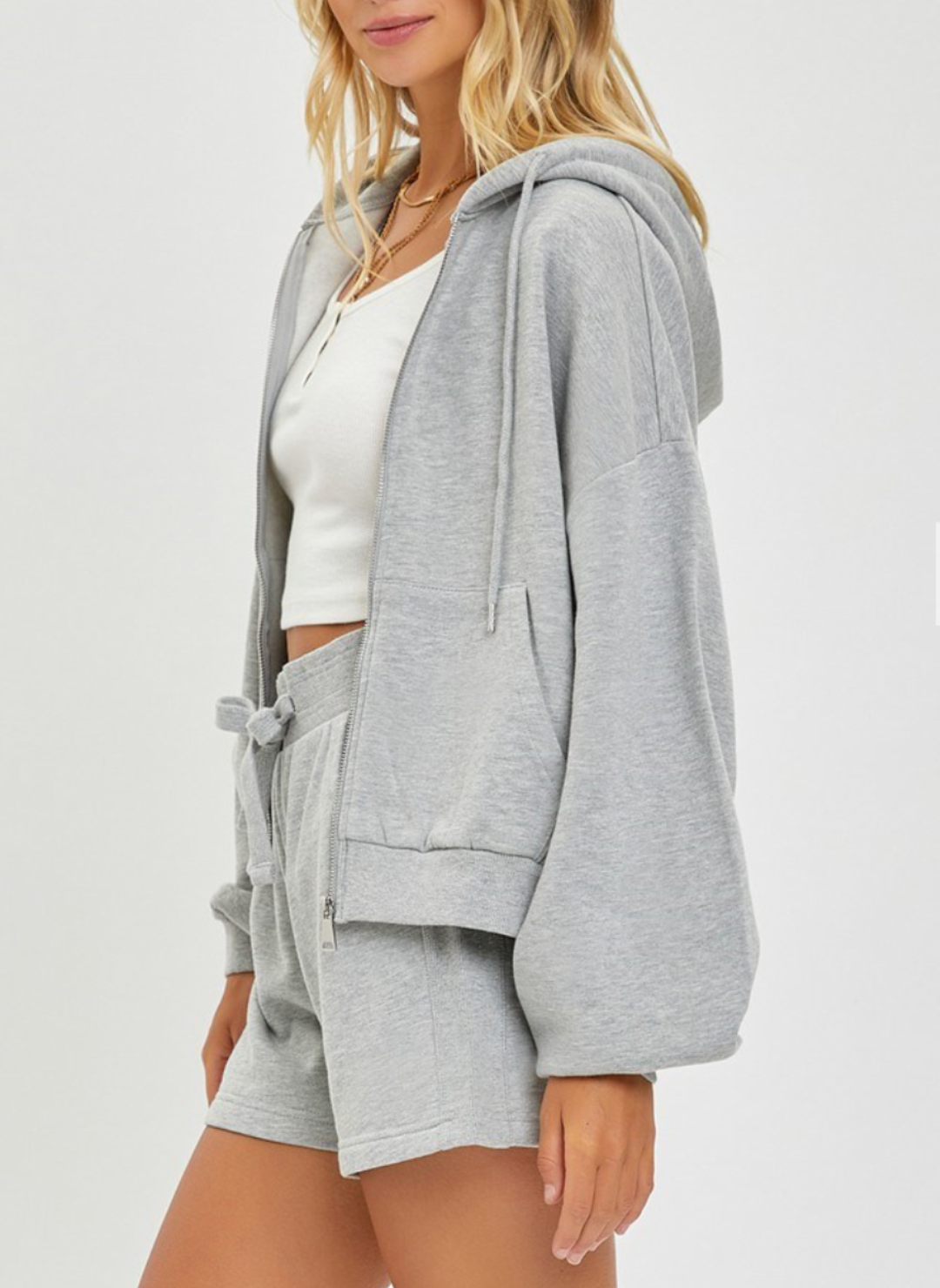 Side/ Front View of the model wearing the Risen Oversized Hoodie opened in the front. Showing the length of the jacket and texture of the hoodie.