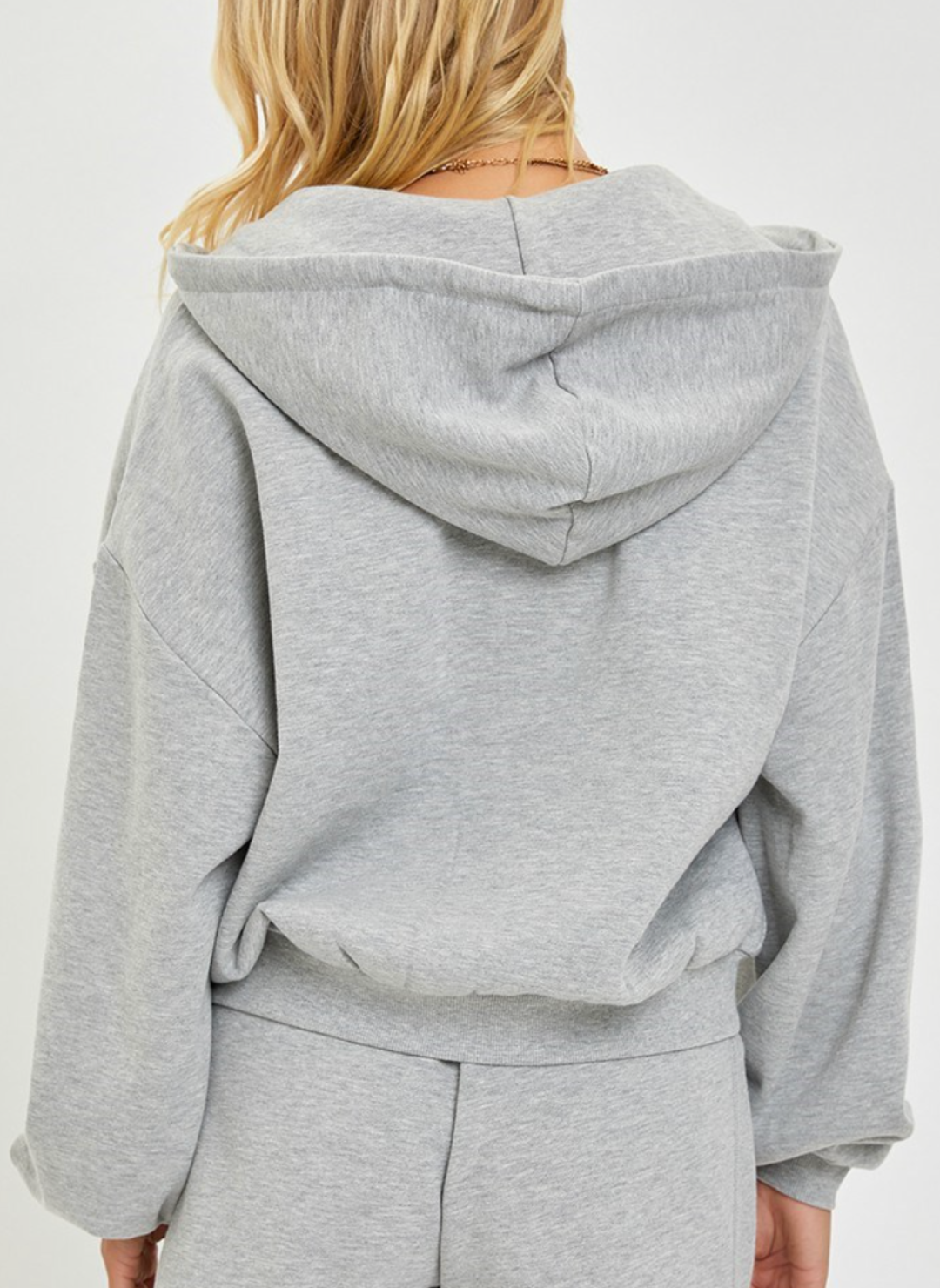 Back view of the Risen Oversized Hoodie showing the hoodie on the back and the elastic waist and how it adds texture.