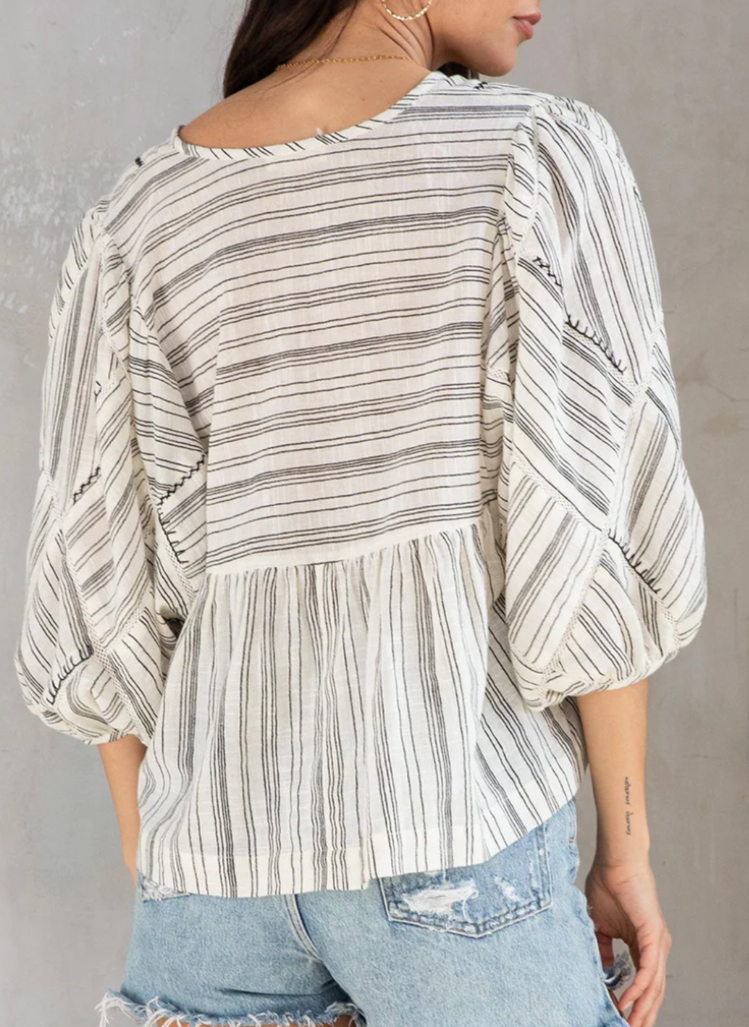 Back view of the model wearing the LS Printed Stripe Top showing the hand embroidery pattern on it. Then showing the back of the sleeves and the back length of the top.