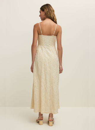 Woman wearing a beige dress with thin straps on a white background