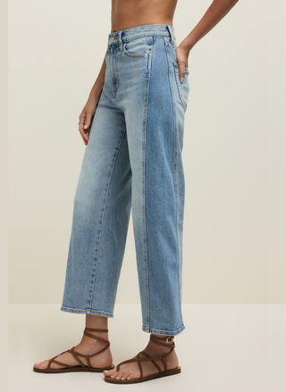 Person wearing light blue jeans on a plain background