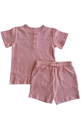 Pink children's shirt and shorts set on a white background