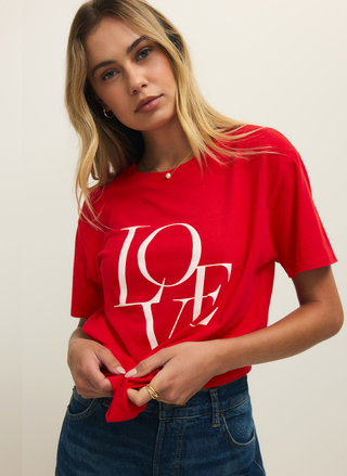 Woman wearing a red 'LOVE' t-shirt against a plain background
