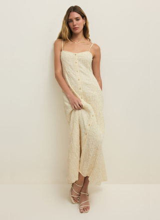 Woman wearing a cream-colored dress against a white background