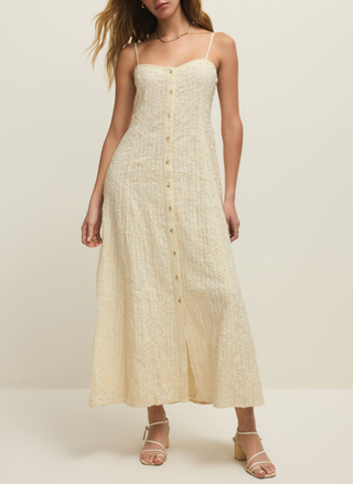 Z Supply Angel Eyes cream colored dress on a model with strappy white sandals on a neutral background. 