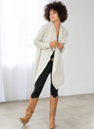 Lovestitch Speckled Shawl Collar Open Front Cardigan in light beige, styled with boots and jeans.