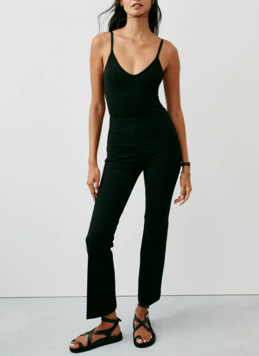 Model is wearing the black spanx flare pant with a black tank