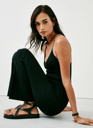 image shows the model in a sideways sitting pose, showing the stretch of the pant