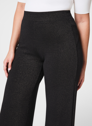 Up close view of pants with subtle sparkle standing in front of white background.