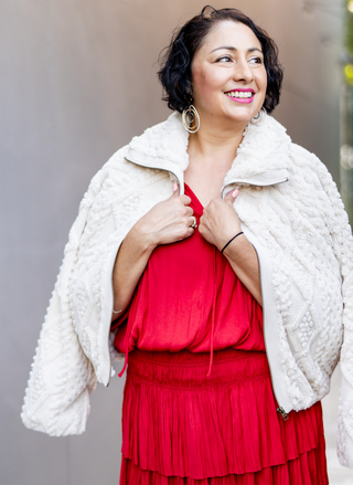 Model wearing the Dylan So Cozy Cable Jacket in ivory over a red dress - August Boutique