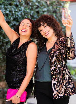 Image shows model wearing the black sparkling tank holding up her champagne glass.