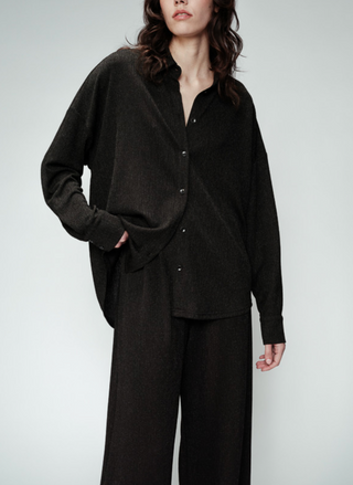 front view of the model wearing the Grace & Mika Olympe Button Down Shirt paired with black pants. Model is standing in front of white background.