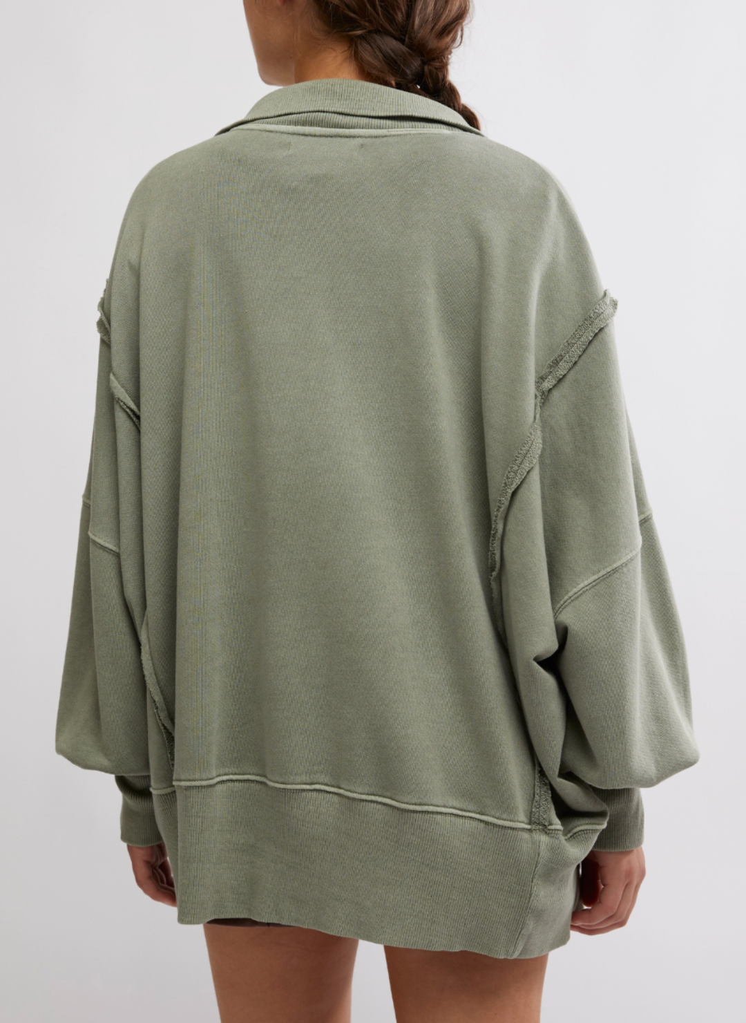 Model is wearing green Camden Pullover Sweatshirt. Models arms are is turned around so the back of the oversized sweatshirt is visible.