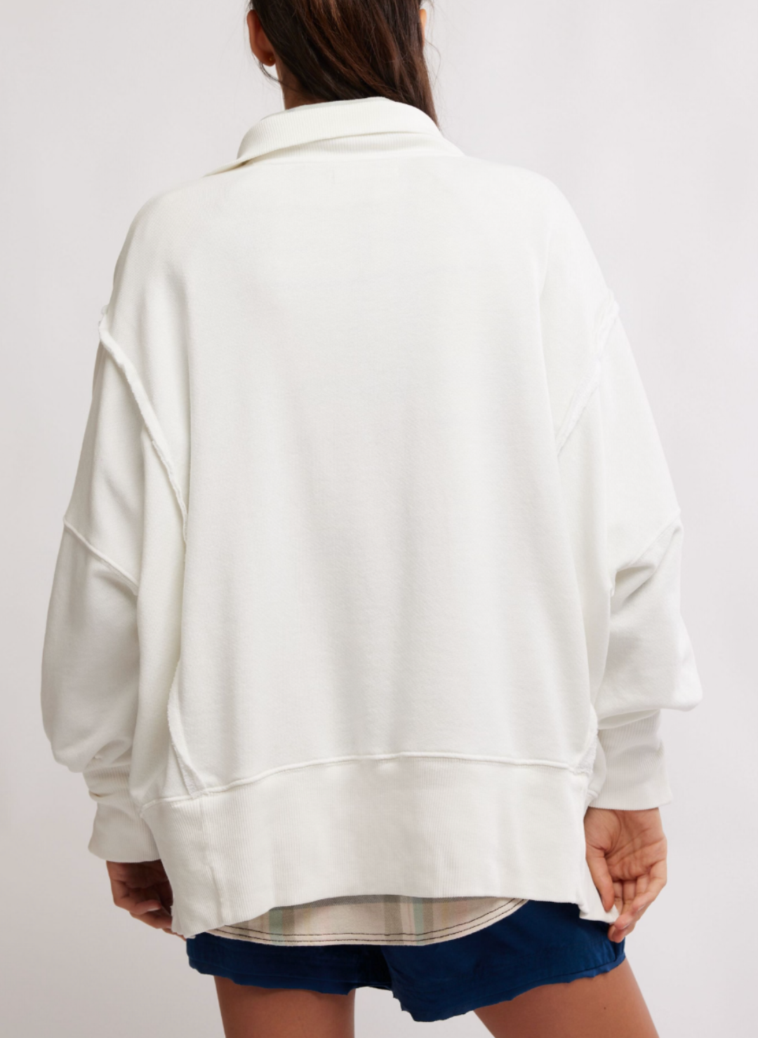 Model is turned away wearing the white Camden pullover sweatshirt showing the oversized fit.